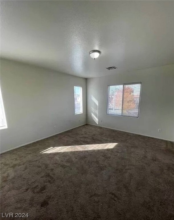 carpeted spare room featuring a textured ceiling