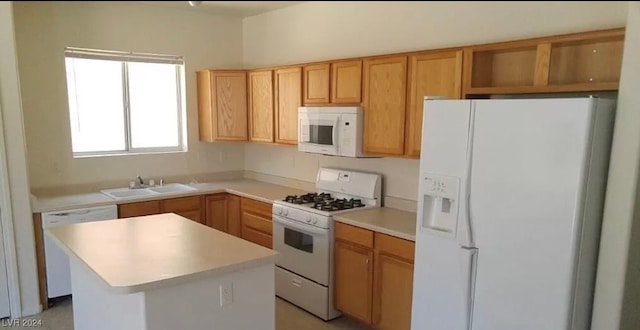 kitchen with a kitchen island, white appliances, and sink