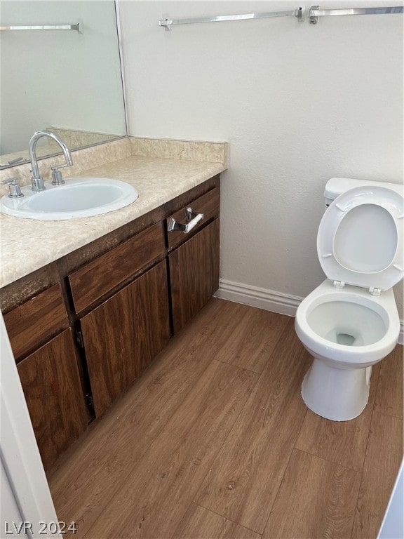 bathroom with vanity, wood-type flooring, and toilet