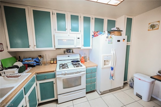 kitchen featuring white appliances, white cabinets, and light tile floors