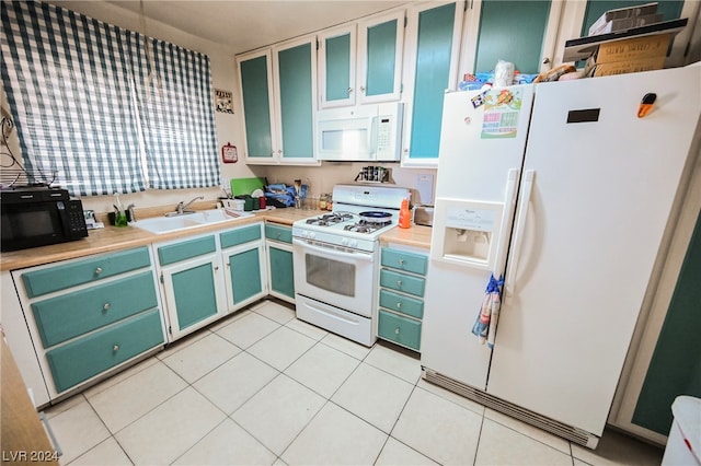 kitchen featuring light tile floors, white appliances, and sink