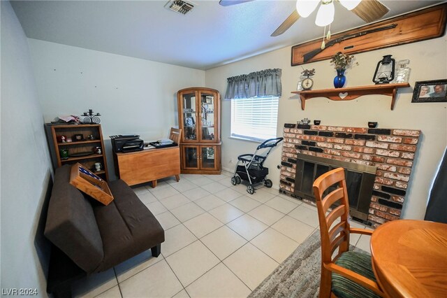 tiled home office with ceiling fan and a fireplace