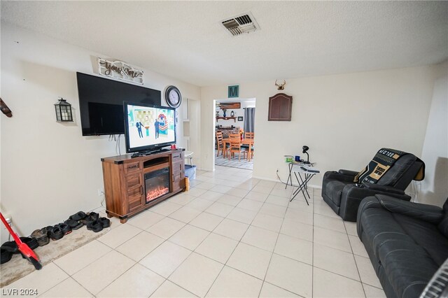 living room with a textured ceiling and light tile flooring