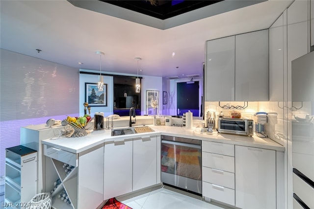 kitchen featuring pendant lighting, sink, light tile floors, and white cabinets