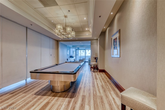 playroom with a raised ceiling, a chandelier, light hardwood / wood-style floors, and billiards