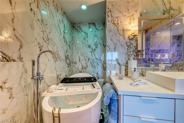 bathroom with tile walls, a washtub, and vanity