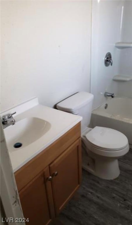 full bathroom with toilet, washtub / shower combination, hardwood / wood-style floors, and vanity