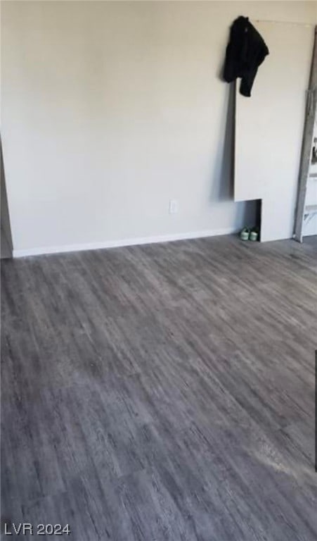 unfurnished room with dark wood-type flooring