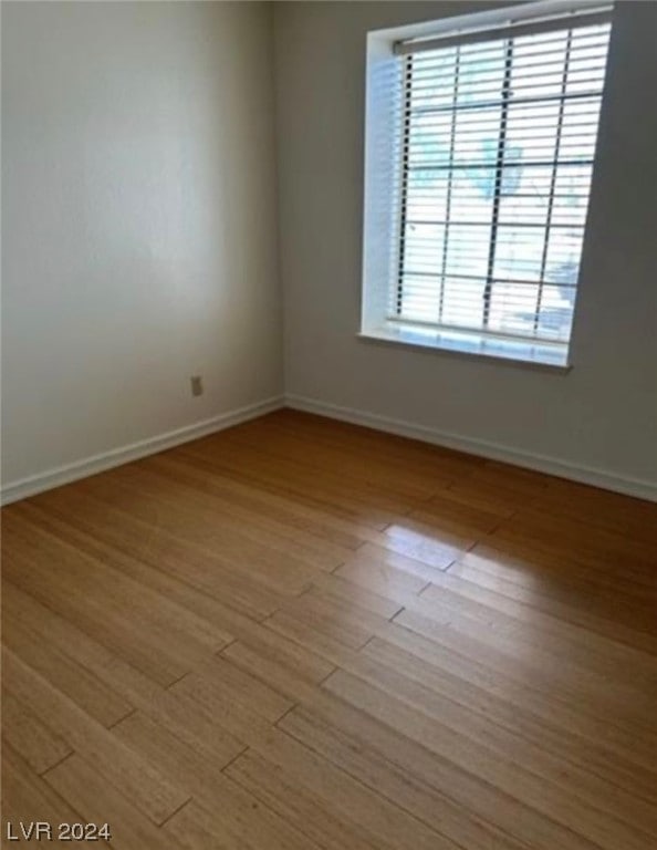 unfurnished room with hardwood / wood-style flooring