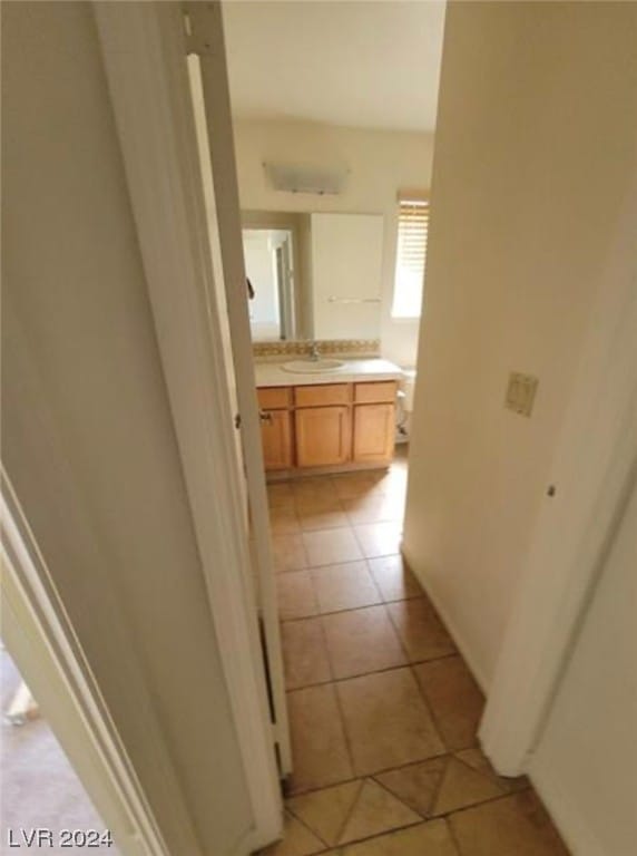 corridor with sink and light tile floors