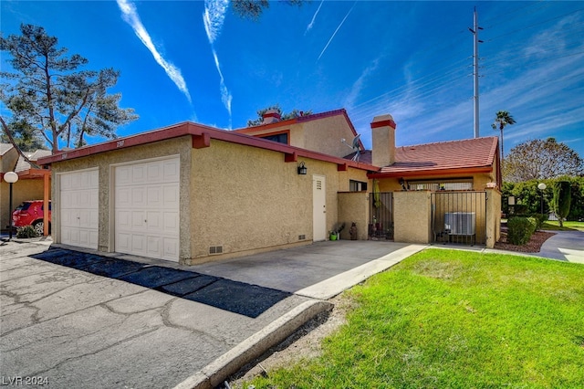 ranch-style house featuring central AC unit, a front lawn, and a garage