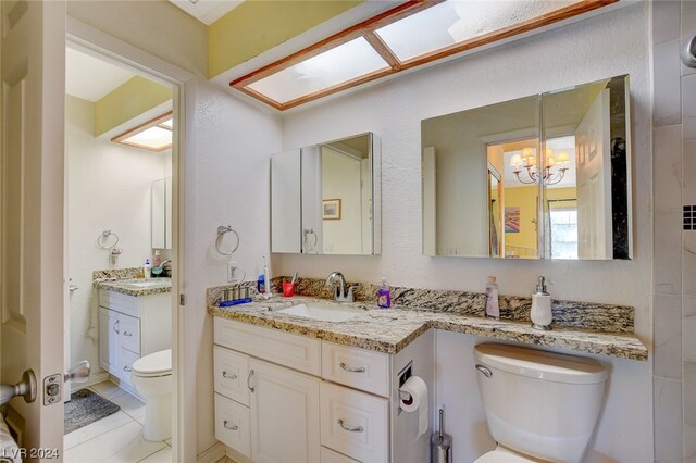 bathroom featuring vanity, tile floors, a chandelier, and toilet