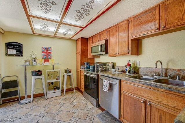 kitchen featuring appliances with stainless steel finishes, light tile floors, and sink