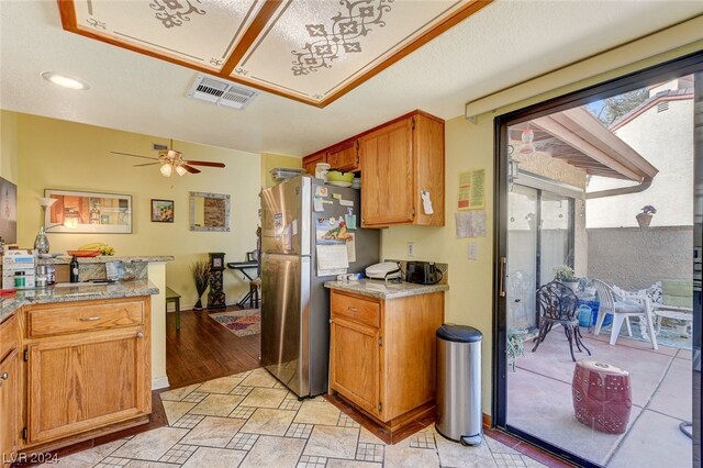 kitchen featuring stainless steel fridge, light tile flooring, and ceiling fan