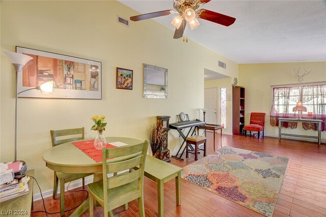 dining room with ceiling fan, hardwood / wood-style flooring, and vaulted ceiling