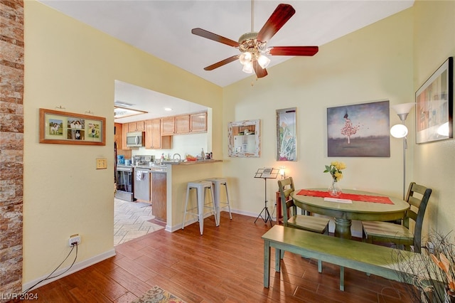 dining room featuring vaulted ceiling, ceiling fan, and hardwood / wood-style flooring