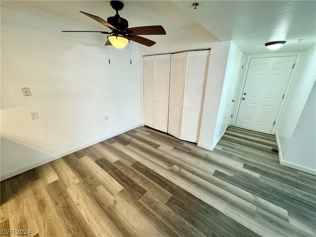 unfurnished bedroom with ceiling fan, dark wood-type flooring, and a closet