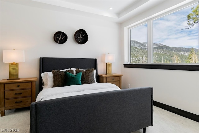 bedroom featuring a mountain view and light carpet