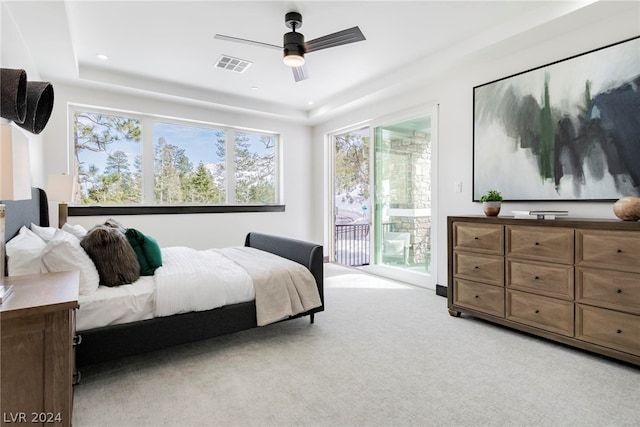 carpeted bedroom with ceiling fan, access to outside, and a tray ceiling