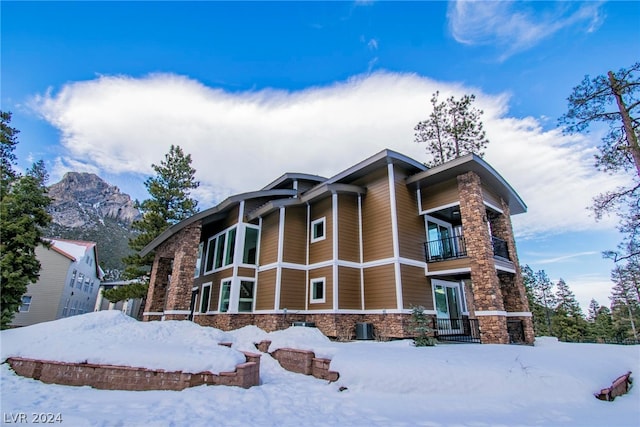 view of front of home with a balcony and a mountain view