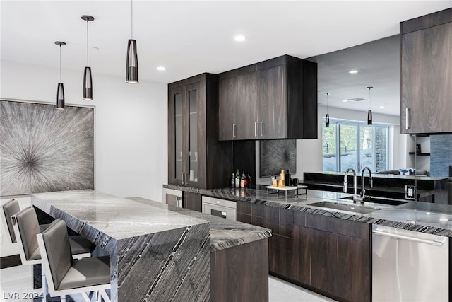 kitchen with stainless steel dishwasher, light stone countertops, hanging light fixtures, and dark brown cabinetry