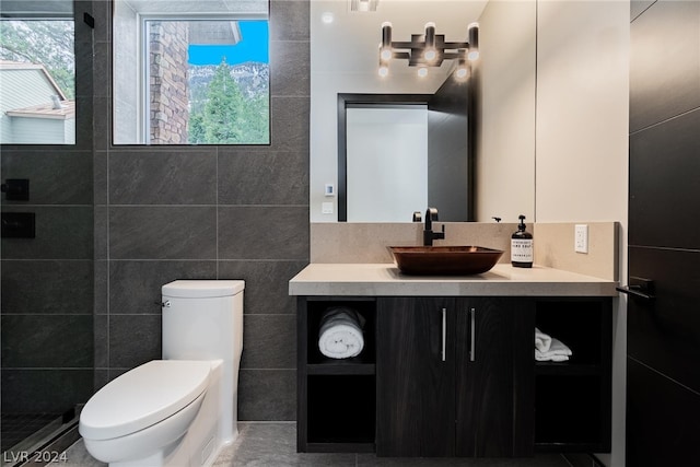 bathroom with toilet, tile flooring, vanity, tile walls, and walk in shower