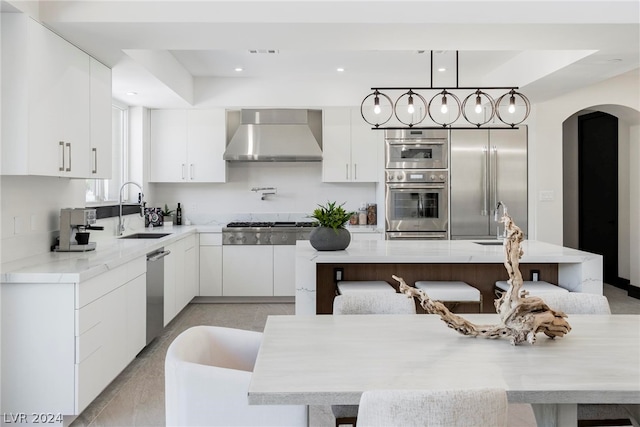 kitchen with white cabinets, stainless steel appliances, wall chimney exhaust hood, and sink