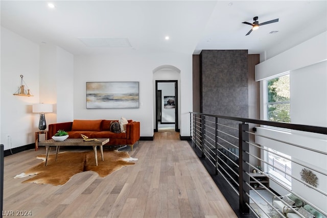 living room with ceiling fan and light wood-type flooring