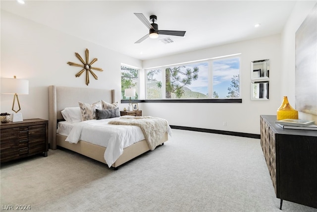 bedroom featuring light colored carpet and ceiling fan