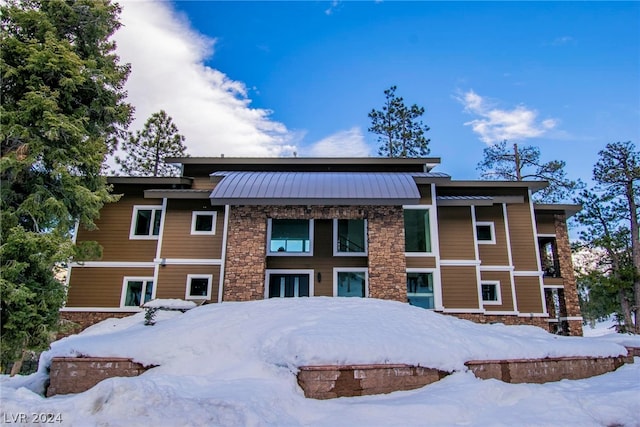 view of snow covered rear of property