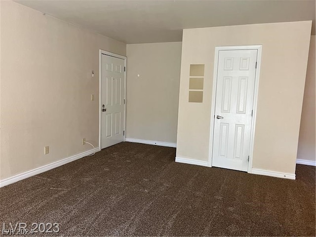 unfurnished bedroom featuring dark carpet