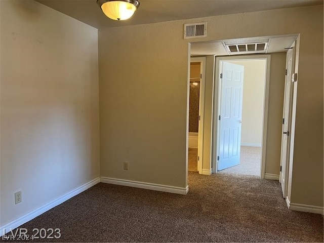 unfurnished room featuring dark carpet