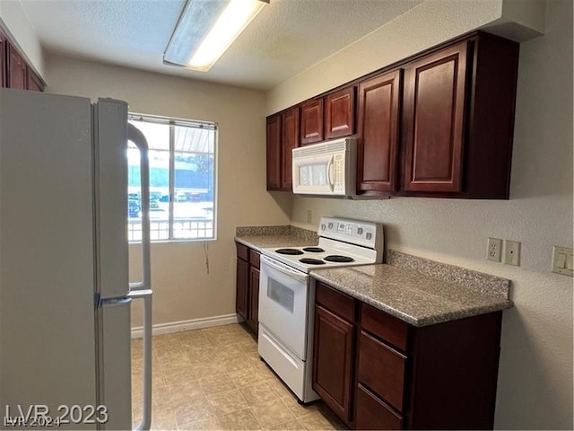 kitchen featuring white appliances, light stone countertops, dark brown cabinetry, and light tile floors