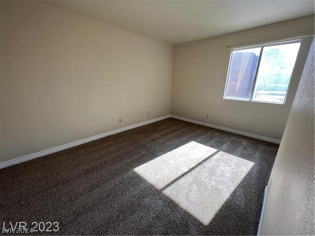 empty room with dark colored carpet