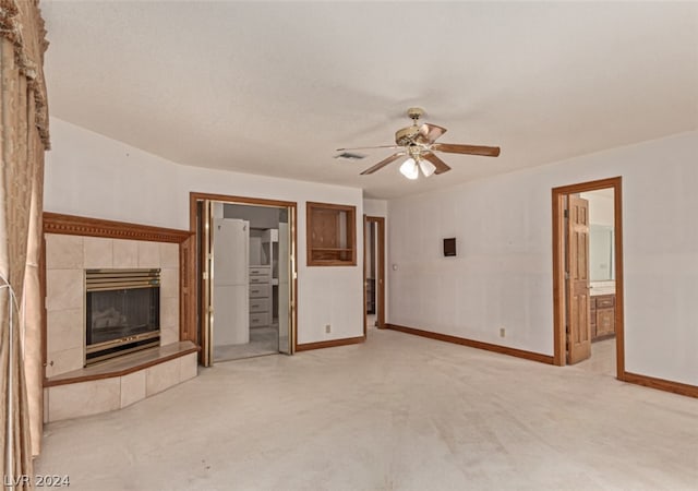 unfurnished living room featuring light colored carpet, a tile fireplace, and ceiling fan