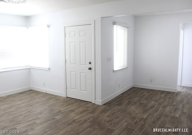 unfurnished room with dark wood-type flooring