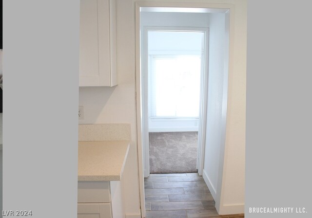 kitchen featuring white cabinets, carpet flooring, and light stone counters