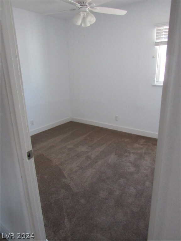 carpeted spare room with ceiling fan