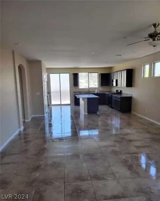 kitchen with ceiling fan, a kitchen island, and tile flooring