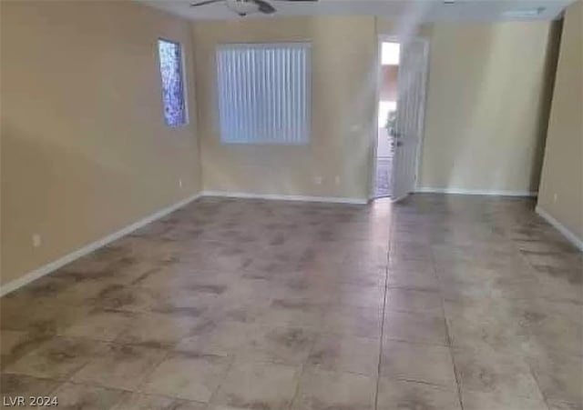 empty room featuring ceiling fan and light tile floors