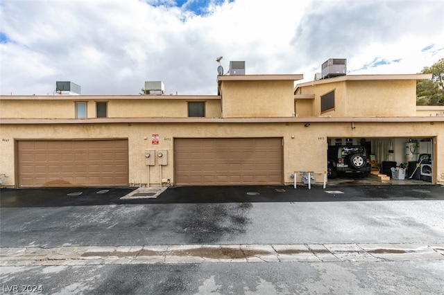 townhome / multi-family property with a garage and central AC