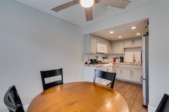 dining space with sink, ceiling fan, light hardwood / wood-style flooring, and a textured ceiling