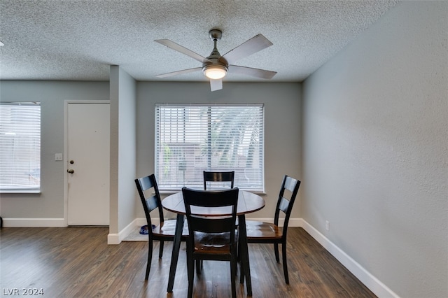 dining space with dark wood-type flooring, ceiling fan, and a textured ceiling