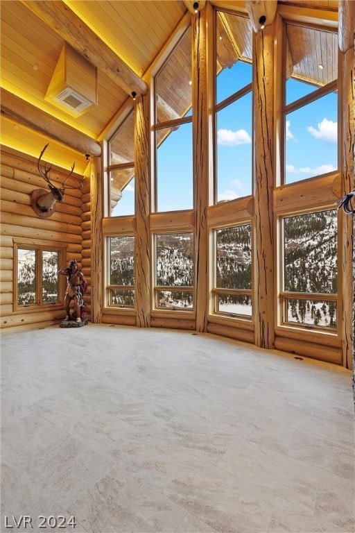 interior space with wooden ceiling, a healthy amount of sunlight, and vaulted ceiling with beams