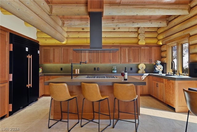 kitchen featuring a kitchen island, log walls, beamed ceiling, island exhaust hood, and high end fridge