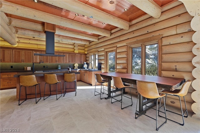 dining room with beamed ceiling, log walls, light tile floors, sink, and wooden ceiling