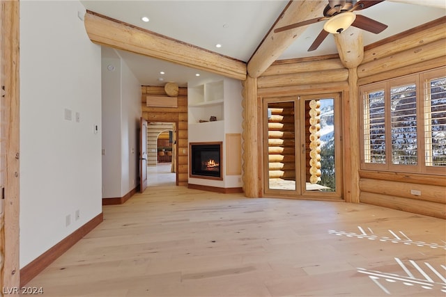 unfurnished living room with log walls, ceiling fan, beamed ceiling, and light hardwood / wood-style floors