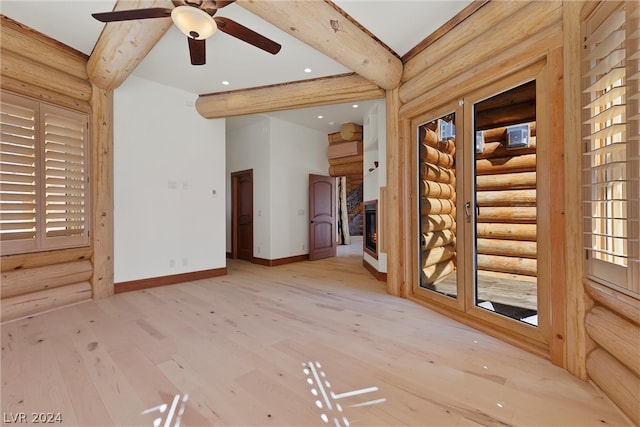 spare room featuring beam ceiling, log walls, ceiling fan, and light wood-type flooring