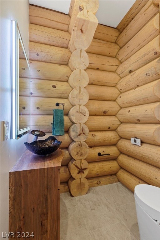 bathroom featuring toilet and rustic walls