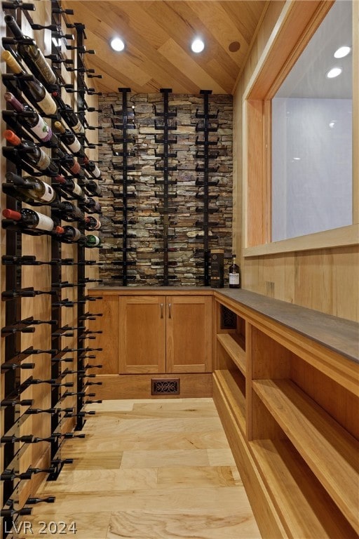 wine cellar featuring light hardwood / wood-style floors, wood ceiling, and lofted ceiling